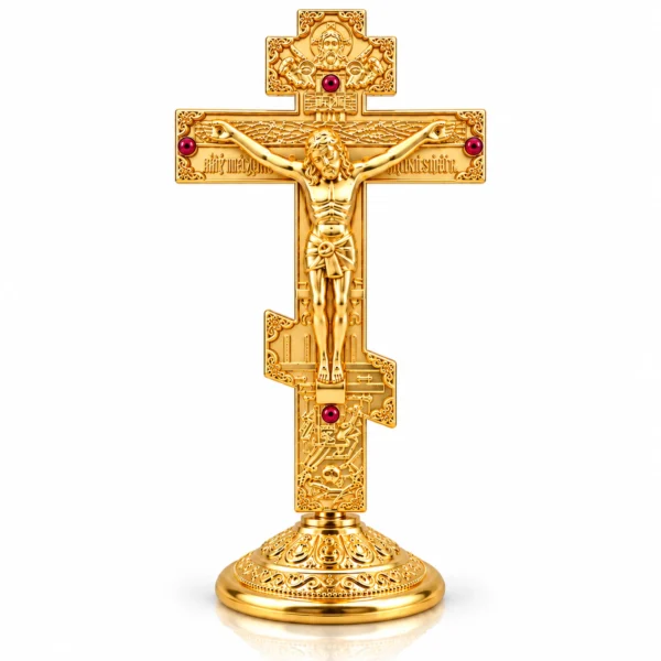 Christliches Standkreuz in Goldoptik mit dekorativem Sockel und roten Schmucksteinen auf weißem Hintergrund