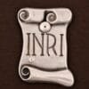 Kruzifix aus Holz – INRI-Schild im Detail INRI-Schriftrolle aus Metall am Kruzifix aus Holz – Detailansicht