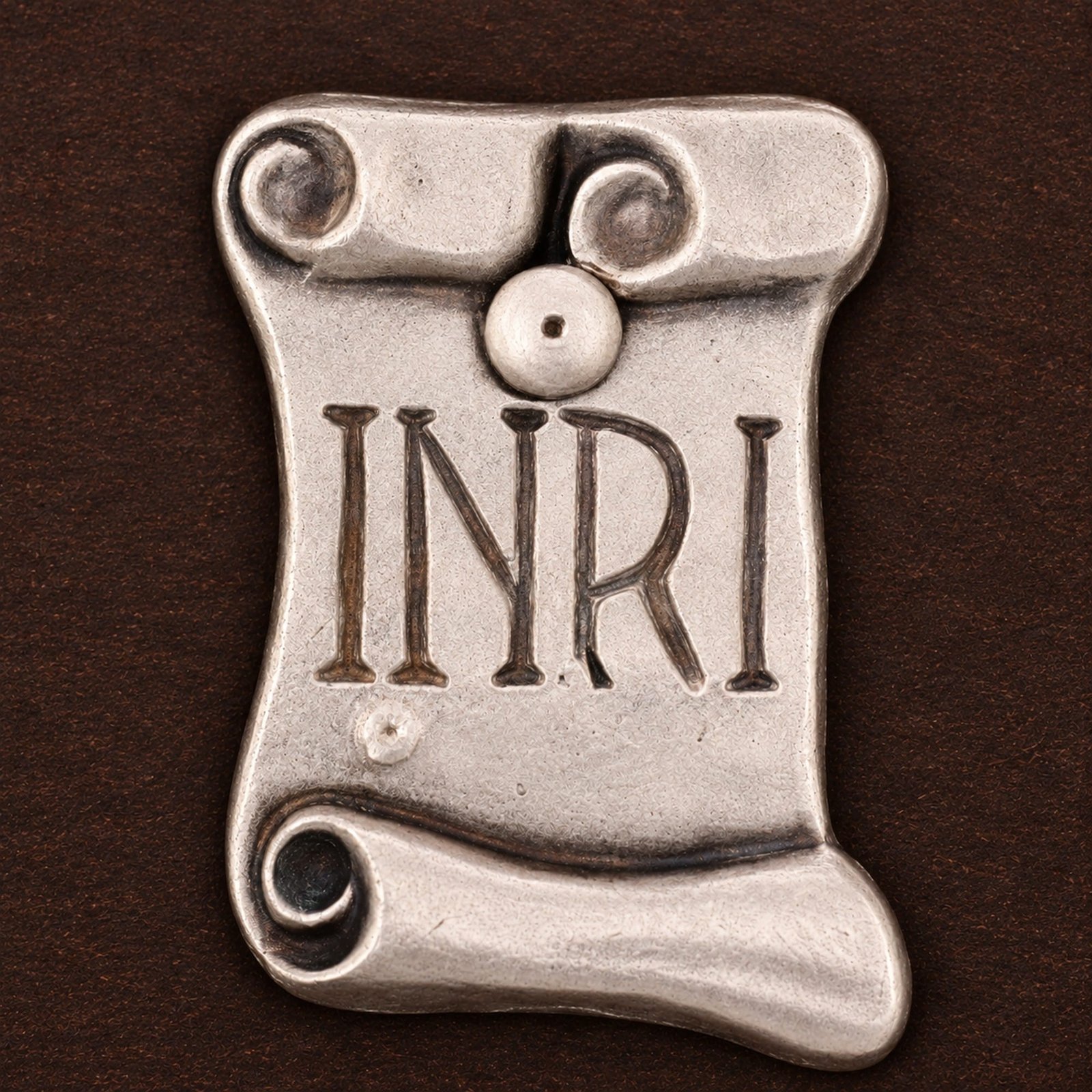 Kruzifix aus Holz – INRI-Schild im Detail INRI-Schriftrolle aus Metall am Kruzifix aus Holz – Detailansicht