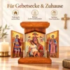 Klappikone aus Holz in einer Gebetsecke neben einer brennenden Kerze