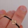 Armband Tiny Cross: kleines Kreuz aus Gold 585 an schwarzer Textilkordel, Ansicht 2